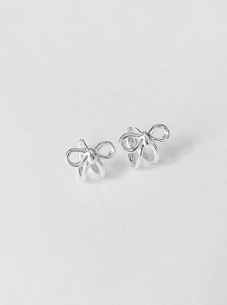 silver bow earrings designed by kara yoo facing foward against a white background
