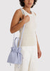 Woman holding a light blue drawstring bag against a white background