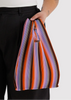 Person holding a colorful striped bag against a white background