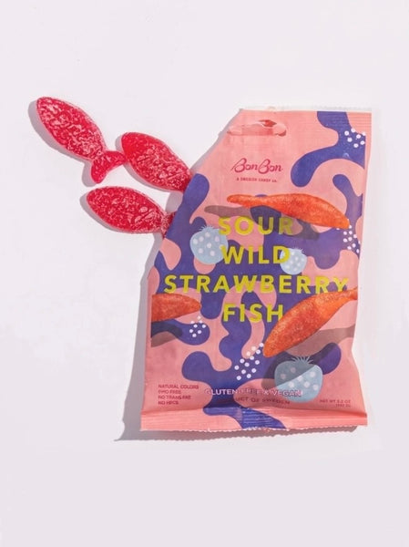 sour wild strawberry gummy fish spilling out of an opened illustrated bonbon nyc candy bag on a white background