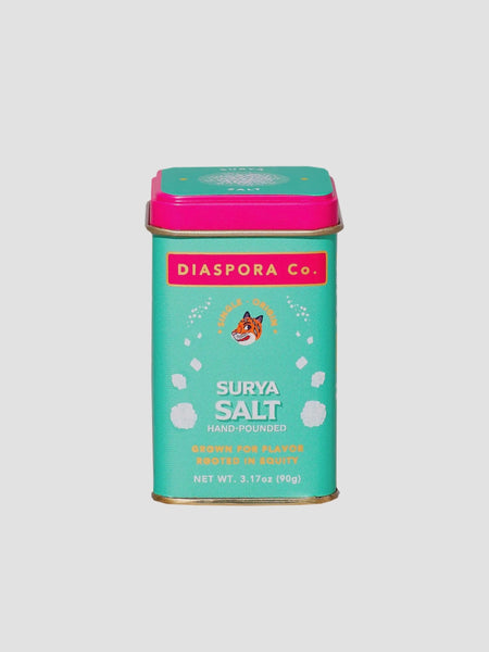 a teal and hot pink tin of surya salt from diaspora co on a white background