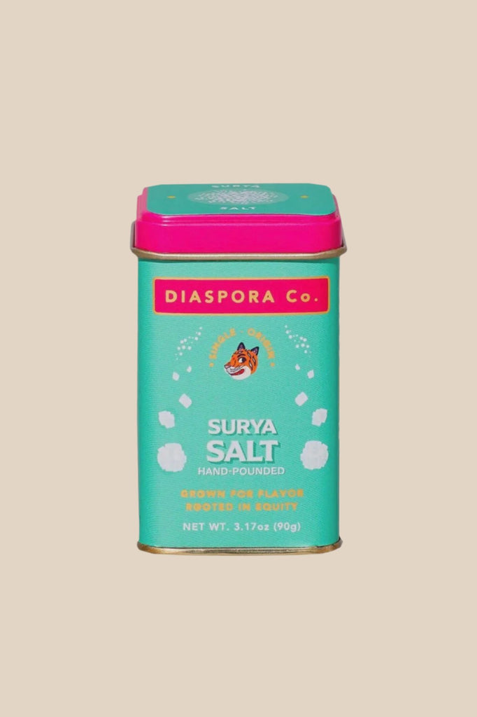 a teal and hot pink tin of surya salt from diaspora co on a white background