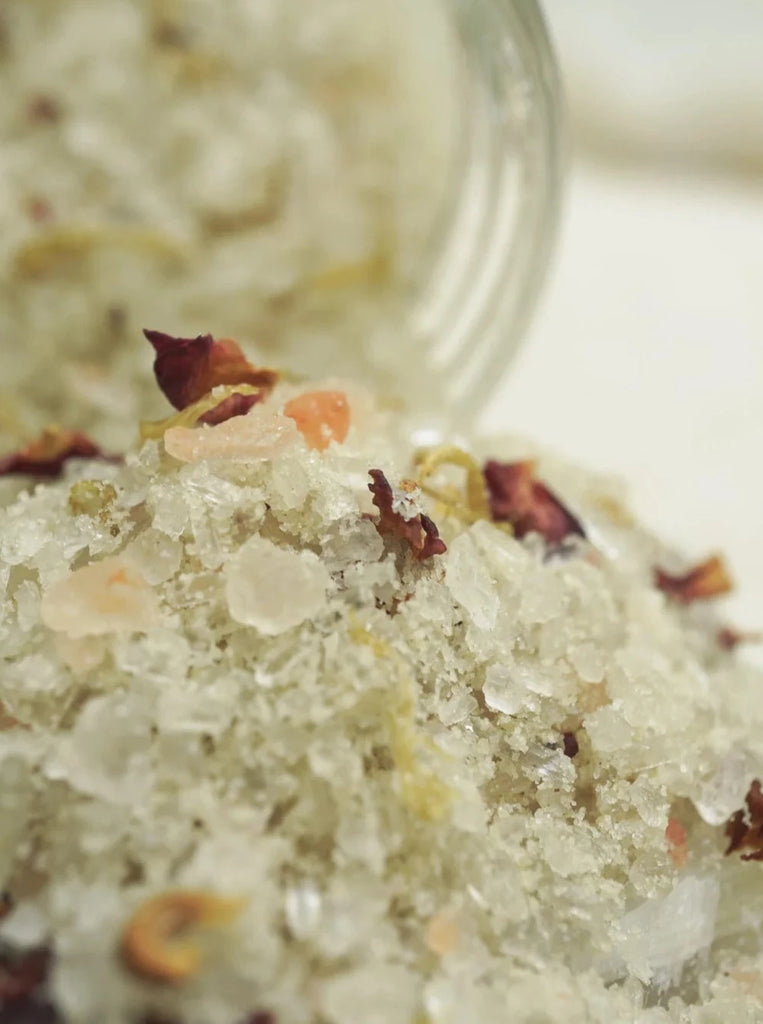 a very close up photo of loose moon salts with rose petals