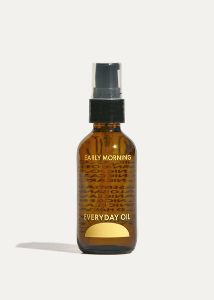 A brown bottle with a dropper, labeled 'Early Morning Everyday Oil' with a text overlay describing the product.