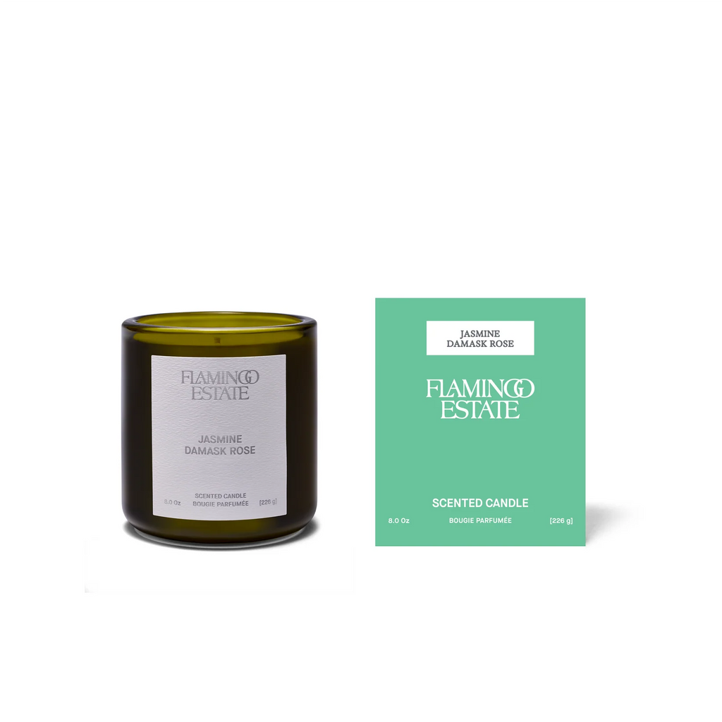 Green candle with label and green packaging on a white background