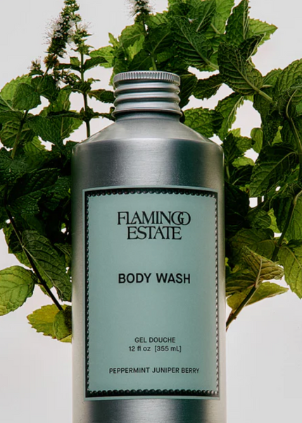 Bottle of Flamingo Estate body wash with green leaves in the background