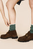 a pair of feet wearing Hansel from Basel's hunter green wool hoodie winter socks with lugsoled loafers.
