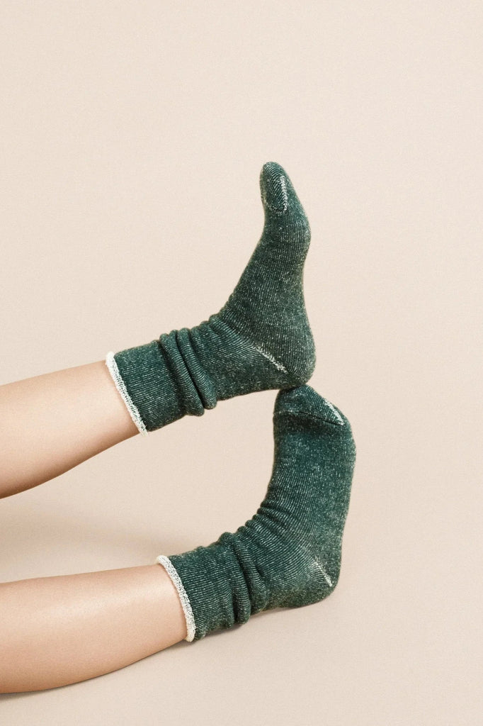 a pair of feet wearing Hansel from Basel's hunter green wool hoodie winter socks.