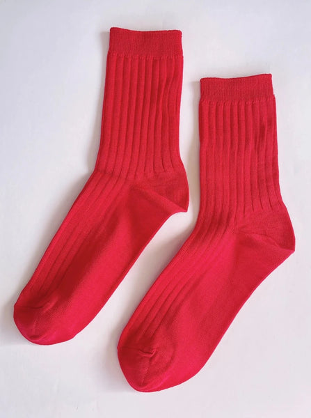 A pair of classic red her socks made of mercerized cotton from Le Bon Shoppe sit on a plain white background