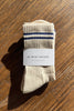 A pair of Girlfriend Socks from Le Bon Shoppe in the color Cashew sit on a plain wooden table