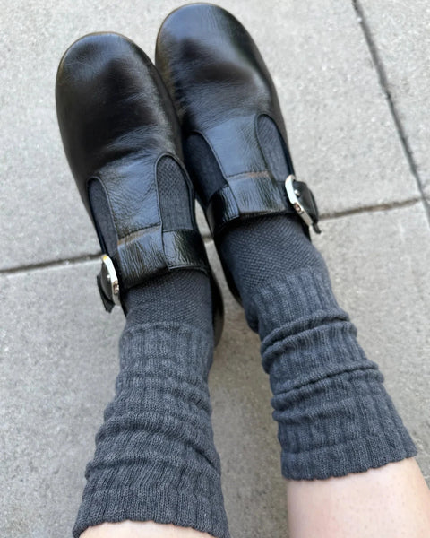 A person wears a pair of Charcoal Ballet Socks from Le Bon Shoppe paired with black leather flats. 