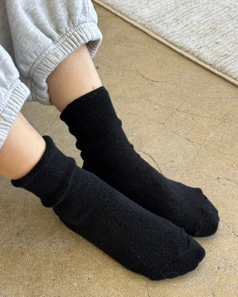 Person wearing Jet Black Cloud Socks from Le Bon Shoppe on a concrete floor