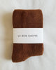 Folded Sepia socks with a white label reading 'Le Bon Shoppe' on a light background