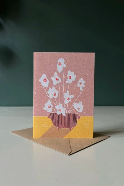 a pink greeting card with white hibiscus flowers in a red pot made by Luiza Holub.