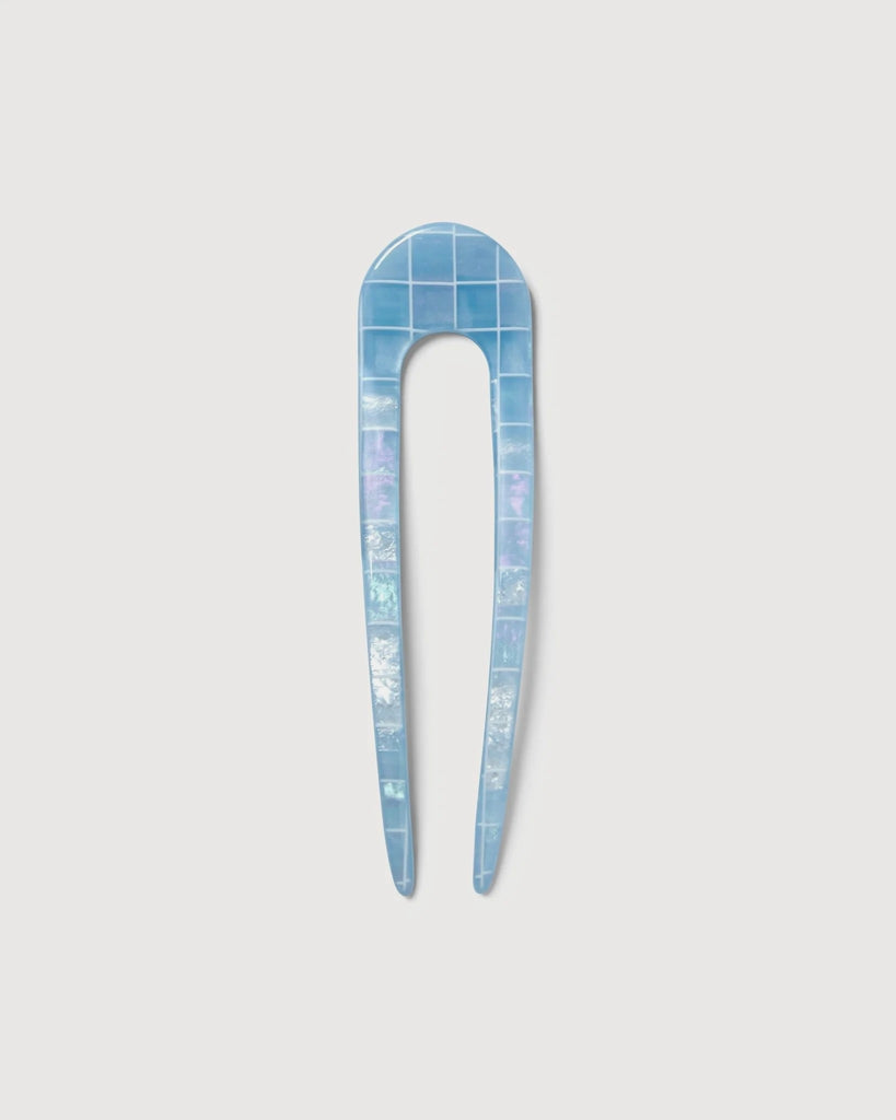 a light blue shell French hair pin by machete sitting on a white background.