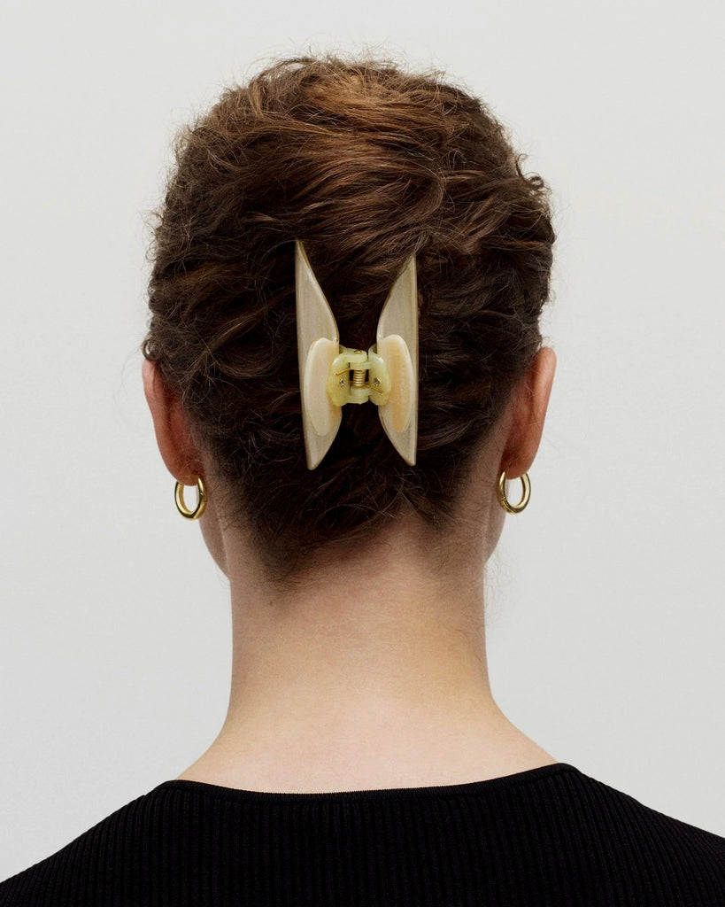 a woman in a black shirt with brown hair wearing a midi heirloom claw hair clip by machete.