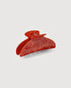 a poppy red midi heirloom claw hair clip by machete sits on a white background.