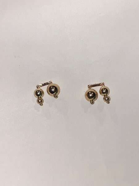 14k gold filled post earrings with asymmetrical beads inspired by Asian lanterns, made by Marida jewelry, sit on a white background