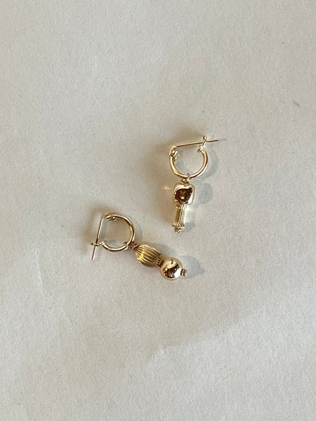 14k gold filled hugging hoop earrings with asymmetrical beads inspired by roman pillars, made by Marida jewelry, sit on a white background