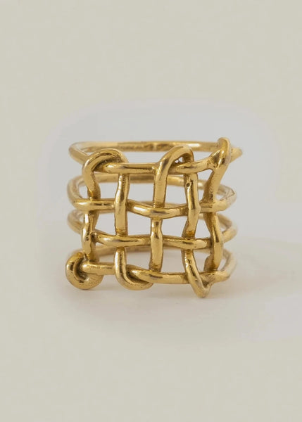Gold woven ring on a light gray background