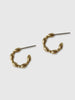 a pair of small brass hoop earrings that look like turned wood on a white background - made by Natalie joy jewelry