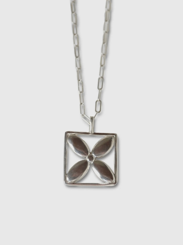 a necklace made by Natalie joy jewelry in sterling silver that looks like a flower inside a square