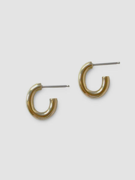 a pair of small brass oval hoop earrings on a white background - made by Natalie joy jewelry