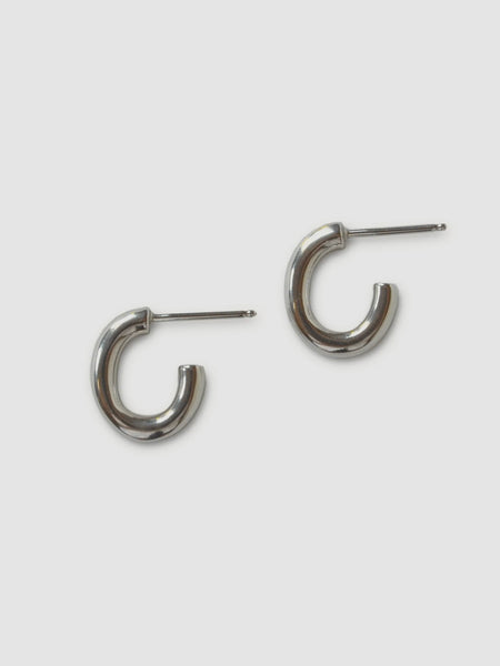 a pair of small oval sterling silver hoops on a white background - made by Natalie joy jewelry