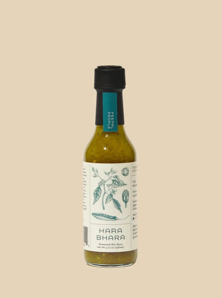 a bottle of peepal people's Hara bhara hot sauce on a creamy beige background