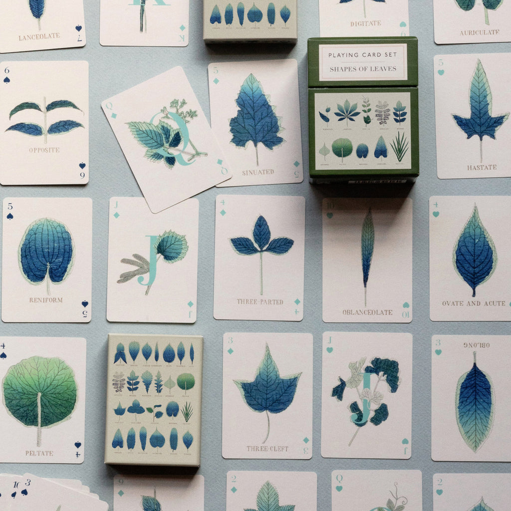 a playing card set featuring illustrations of leaves.