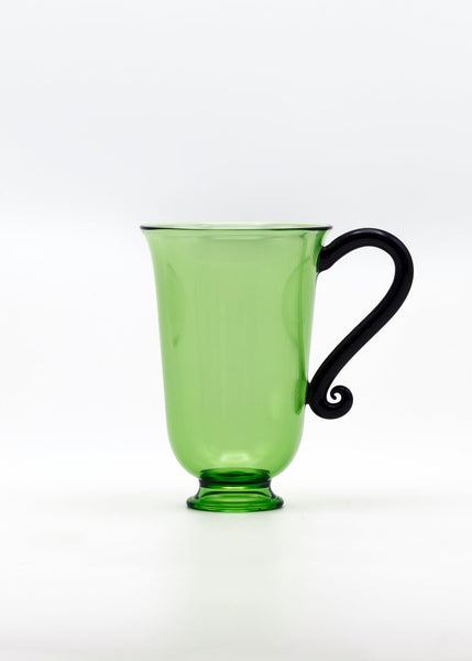 Green glass mug with a black handle on a white background