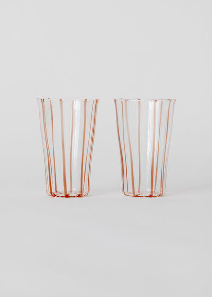 Two clear glasses with red stripes on a white background