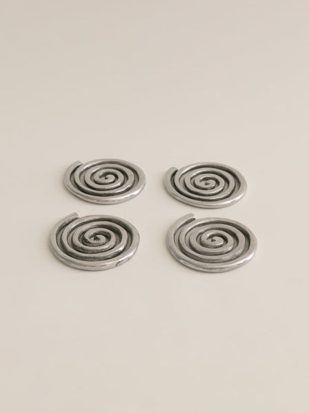 four silver spiral metal coasters 