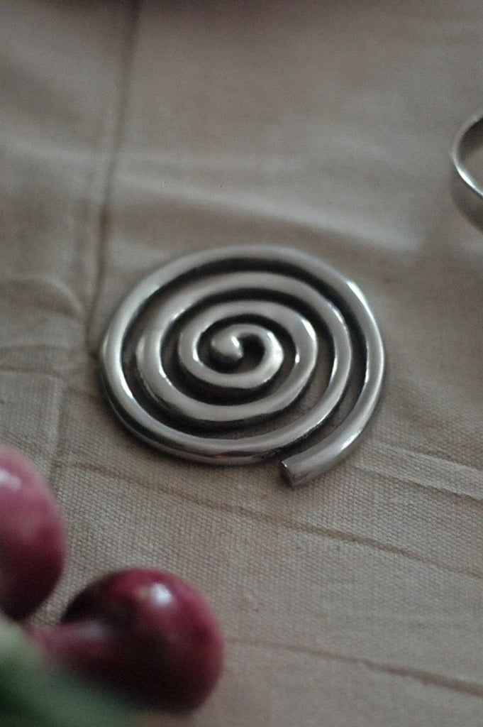 silver spiral metal coaster on canvas tablecloth