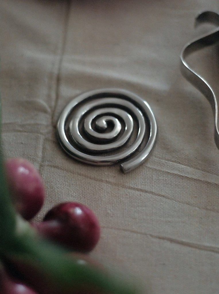 silver spiral metal coaster on canvas tablecloth