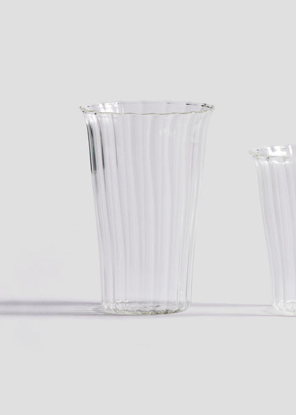 Two clear glass tumblers on a light gray background