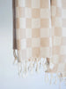 a close up photo of tan colored checkerboard Turkish hand towel