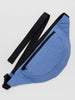 A pansy blue crescent shaped nylon fanny pack with a black front zipper and black strap made by baggu against a white background