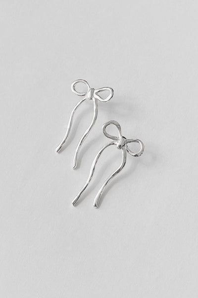 silver earrings shaped like bows by Kara Yoo against a white background 