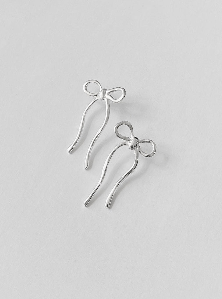 silver earrings shaped like bows by Kara Yoo against a white background 