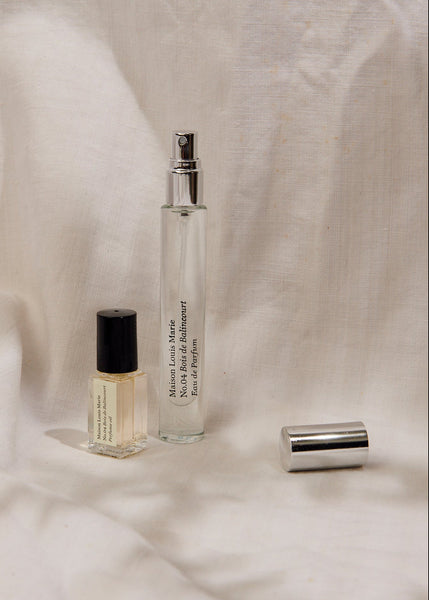 Two perfume bottles on a textured beige fabric background