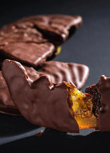 Chocolate covered orange slices on a dark background